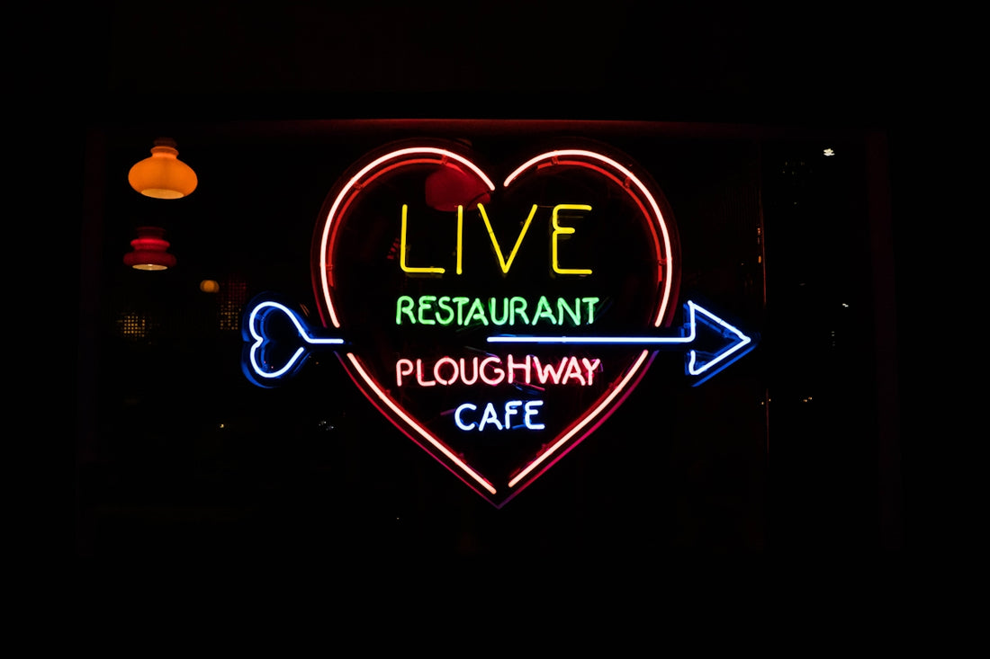 a neon sign that says live restaurant ploughway cafe