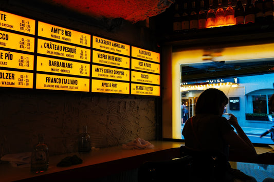 Illuminated menu board above a bar counter