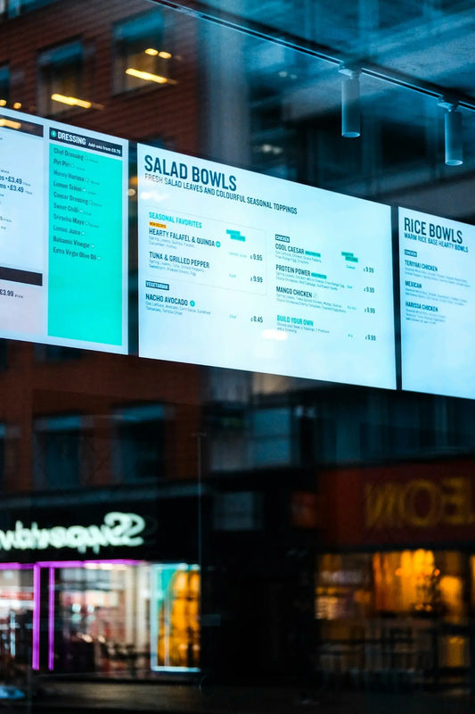 Digital menu boards display salad and rice bowls.