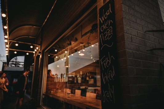 A restaurant storefront with string lights and menu board.